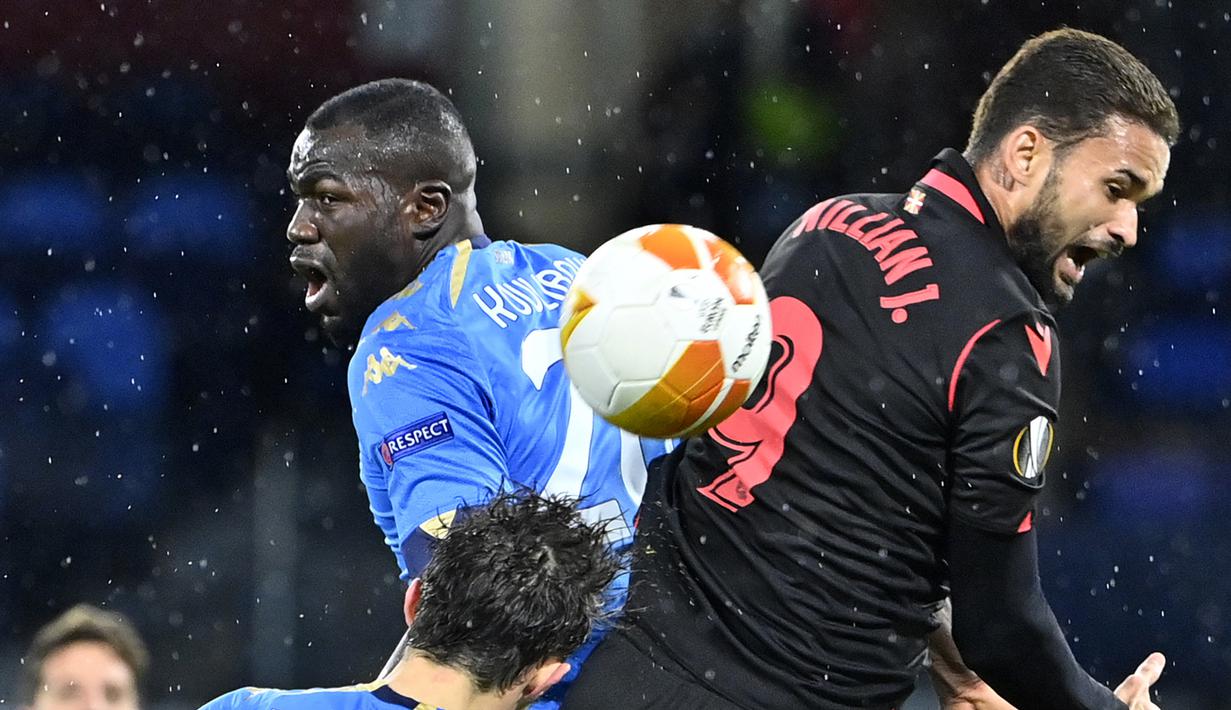 Bek Napoli, Kalidou Koulibaly (kiri), berduel udara dengan striker Real Sociedad, Willian Jose, dalam laga lanjutan Liga Europa 2020/21 Grup F di Diego Armando Maradona Stadium, Kamis (10/12/2020). Napoli bermain imbang 1-1 dengan Real Sociedad. (AFP/Alberto Pizzoli)