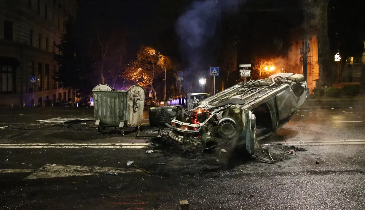 Sebuah mobil polisi terbakar dekat sisa-sisa barikade setelah bentrokan antara demonstran dan polisi di sebuah jalan dekat Gedung Parlemen Georgia, Tbilisi, Georgia, Kamis (9/3/2023). Delegasi Uni Eropa untuk Georgia menyambut langkah pemerintah Georgia itu dengan menyeru semua pemimpin politik Georgia memulai kembali reformasi pro Uni Eropa melalui cara inklusif dan konstruktif. (AP Photo/Zurab Tsertsvadze)