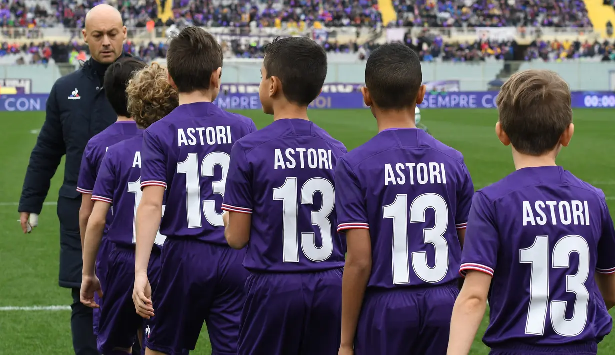 Anak-anak mengenakan seragam Fiorentina dengan nama punggung Astori dan bernomor 13 jelang pertandingan Fiorentina vs Benevento di stadion Artemio Franchi di Florence (11/3). (AFP Photo/Claudio Giovannini)
