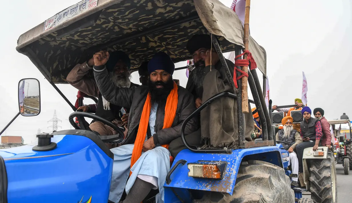 Para petani membawa traktor berpartisipasi dalam unjuk rasa di Jalan Tol Kundli – Manesar – Palwal (KMP) di Kundli di negara bagian Haryana (7/1/2021). Pawai serupa juga diselenggarakan para petani di Burari di ibu kota negara. (AFP/Prakash Singh)