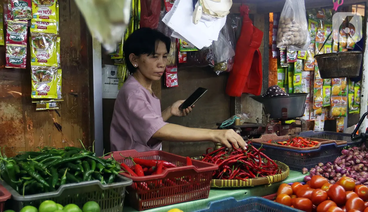 Wahyuning menata kebutuhan pokok dagangannya di Pasar Pondok Labu, Jakarta, Rabu, (8/6/2022). Beberapa harga kebutuhan pokok terus mengalami kenaikan, khususnya cabai rawit merah. (Liputan6.com/Johan Tallo)