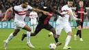 Pemain Bayer Leverkusen, Jeremie Frimpong, berusaha melepaskan diri dari adangan pemain Stuttgart, Josha Vagnoman dan Atakan Karazor pada laga perempat final DFB Pokal di Stadion di BayArena, Rabu (7/2/2024). Kemenangan ini membawa Bayer Leverkusen ke semifinal DFB Pokal. (AP Photo/Martin Meissner)