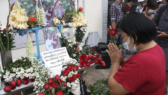 Seorang wanita berdoa saat memberi penghormatan kepada seorang guru yang tewas dalam protes kudeta militer di Yangon, Myanmar, Senin (1/3/2021). Seorang guru perempuan tewas setelah polisi melemparkan granat setrum untuk membubarkan aksi protes yang digelar para guru di Yangon. (AP Photo)