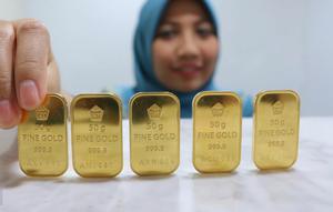 Seorang pegawai menunjukan emas batangan di Jakarta, Senin (10/10). Harga jual emas PT Aneka Tambang (Persero) Tbk (Antam) pada perdagangan awal pekan ini terpantau stagnan. (Liputan6.com/Angga Yuniar)