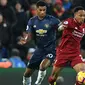 Bek Liverpool, Nathaniel Clyne, berebut bola dengan striker Manchester United, Marcus Rashford, pada laga Premier League di Stadion Anfield, Liverpool, Minggu (16/12). Liverpool menang 3-1 atas MU. (AFP/Paul Ellis)