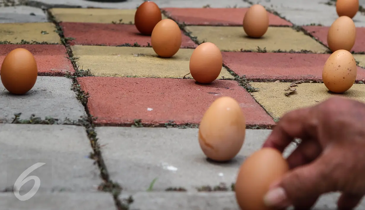 Telur ayam berdiri sendiri pada perayaan Peh Cun di Pasar Lama, Kota Tangerang, (9/6). Fenomena ini akibat posisi matahari berada pada titik kulminasi terdekat dengan bumi sehingga pengaruh gravitasi terhadap bumi lebih kuat. (Liputan6.com/Fery Pradolo)