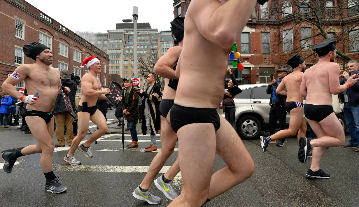 Pelari berjalan menyusuri Newbury Street selama Santa Speedo Run di Boston, Massachusetts, Sabtu (14/12/2019). Acara yang menjadi tradisi tahunan  tersebut bertujuan untuk mengumpulkan donasi untuk membantu anak-anak setempat yang membutuhkan. (Joseph Prezioso/AFP)
