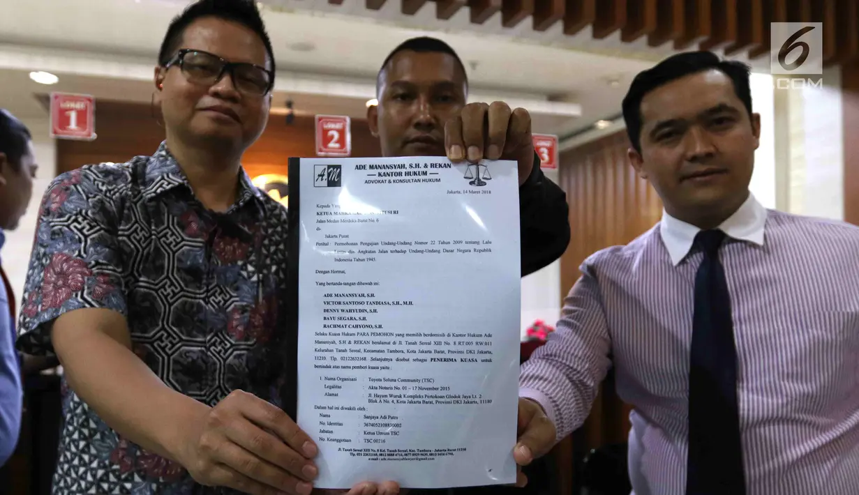 Pengemudi taksi online berserta kuasa hukumnya menyerahkan permohonan uji materi UU Lalu Lintas dan Angkutan Jalan ke MK di Jakarta, Rabu (14/3). Mereka meminta MK mengkaji aturan bagi pengguna GPS di HP akan ditilang. (Liputan6.com/Angga Yuniar)