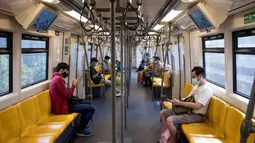 Para penumpang yang memakai masker memeriksa ponsel mereka di kereta layang atau BTS Skytrain di Bangkok, Thailand pada Senin (4/1/2021). Pejabat kesehatan di Thailand pada Senin mencatat 745 kasus virus corona baru, rekor tertinggi harian di negara itu sejak awal pandemi COVID-19. (Jack TAYLOR / AF