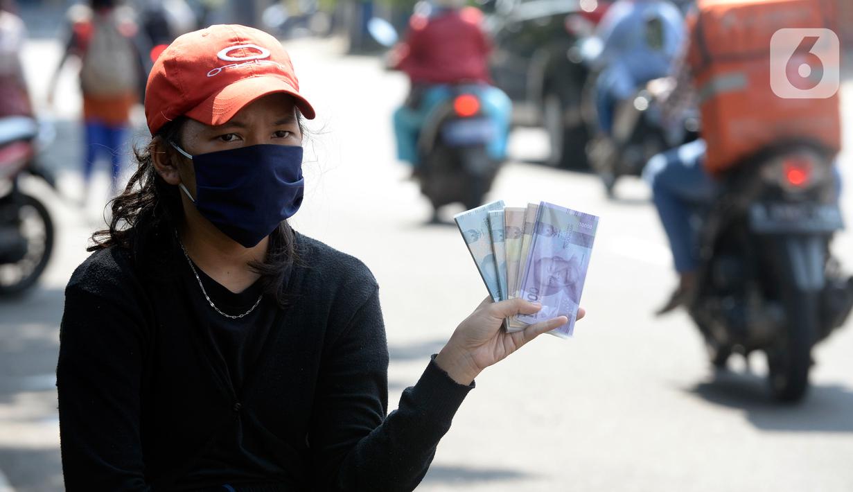 Penjual jasa penukaran uang menawarkan uang baru berbagai pecahan kepada pengguna jalan di kawasan Bintaro Sektor 2, Jakarta Selatan, Selasa (12/05/2020). Menjelang perayaan Lebaran, jasa penukar uang keliling yang berada di pinggir jalan-jalan utama mulai bermunculan. (merdeka.com/Dwi Narwoko)