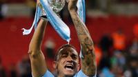 Pemain Manchester City, Danilo mengangkat trofi Piala Liga Inggris seusai mengalahkan Arsenal di Stadion Wembley, Minggu (25/2). Trofi ini sekaligus menjadi trofi pertama yang disumbangkan oleh sang manajer Pep Guardiola. (AP/Tim Ireland)