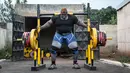 Iron Biby berlatih di rumahnya di Bobo-Dioulasso, kota terbesar kedua di Burkina Faso pada 24 September 2018. Bernama asli Cheick Ahmed al-Hassan Sanou, Iron Biby digadang sebagai pria terkuat se-Burkina Faso. (OLYMPIA DE MAISMONT / AFP)