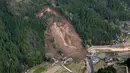 Kondisi tempat terjadi longsor yang menghantam rumah hunian di Nakatsu, Prefektur Oita, Jepang (11/4). Longsor tersebut juga memutus salah satu akses jalan ke lokasi. (Takuto Kaneko/Kyodo News via AP)
