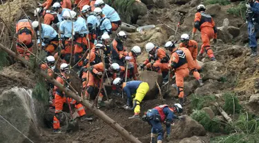 Petugas penyelamat dan polisi berusaha mencari korban usai terjadi longsor yang menghantam rumah hunian di Nakatsu, Prefektur Oita, Jepang (11/4). Sedikitnya enam orang hilang setelah tertimbun longsor. (AFP Photo/Jiji Press/Japan Out)