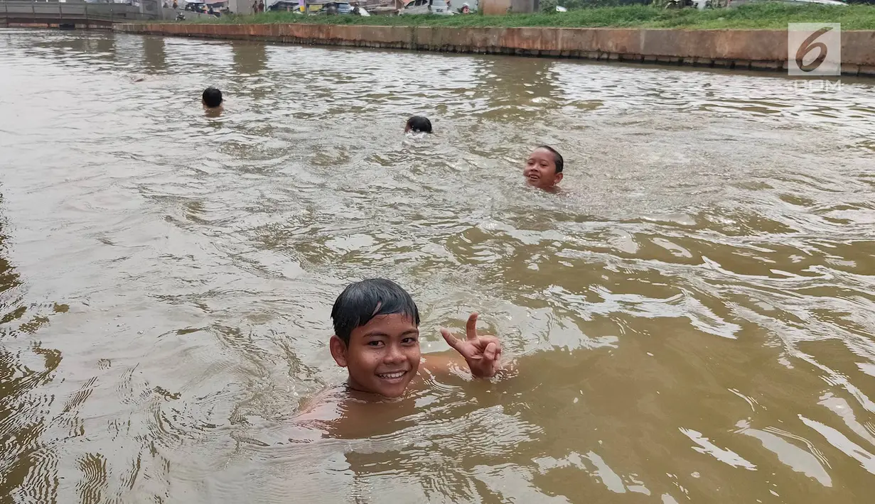 Anak-anak berenang di Sungai Kalimalang, Jakarta Timur, Jumat (5/7/2019). Tingginya suhu udara Ibu Kota akibat musim kemarau menyebabkan anak-anak tersebut berenang di Sungai Kalimalang meski dengan kondisi seadanya. (Liputan6.com/Immanuel Antonius)