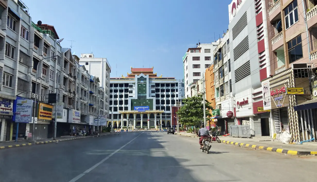 Seorang pria mengendarai sepeda motor di jalan kosong dekat stasiun kereta api di Mandalay, Myanmar, Jumat (10/12/2021). Banyak kantor, toko dan restoran tutup dan orang-orang tinggal di dalam rumah sebagai protes atas pengambilalihan militer ketika aksi mogok senyap atau "silent strike". (AP Photo)