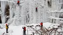 Orang-orang memanjat dinding es buatan di kota Liberec, Republik Ceko, Minggu (27/1). Meski buatan, tidak sembarang orang bisa menaklukkan tebing es tersebut. (AP Photo/Petr David Josek)