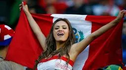 Suporter cantik dan seksi Peru bersorak membentangkan bendera negaranya saat menyaksikan laga Timnas Peru vs Brasil dalam laga Copa America 2015 di Temuco, Chile (14/6/2015). (REUTERS/Ricardo Moraes)