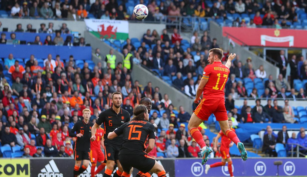 <p>Bek Wales, Rhys Norrington-Davies (kanan) menyundul bola saat bertanding melawan Belanda selama pertandingan grup A4 UEFA Nations League di stadion Cardiff City di Cardiff, Wales selatan, Kamis (9/6/2022). Belanda menang tipis atas Wales 2-1. (AFP/Geoff Caddick)</p>