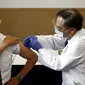 Direktur Pusat Medis Tokyo Kazuhiro Araki (kiri) menerima dosis vaksin virus corona COVID-19 di Tokyo, Jepang, Rabu (17/2/2021). Jepang memulai kampanye vaksinasi COVID-19 dengan suntikan COVID-19 pertama Jepang diberikan kepada petugas kesehatan. (Behrouz Mehri/Pool Photo via AP)