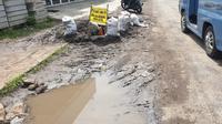 Bekas galian fiber optik di jalan terusan Aruji dekat kompleks SOR Ciateul, kecamatan Tarogong Kidul, dibiarkan berantakan tanpa perbaikan. (Liputan6.com/Jayadi Supriadin)