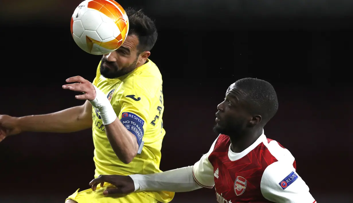 Bek Villareal, Mario Gaspar berebut bola dengan penyerang Arsenal, Nicolas Pepe pada leg kedua semifinal Liga Europa di Emirates Stadium, Jumat (7/5/2021) dinihari WIB. Villarreal menyingkirkan Arsenal dan lolos ke final setelah mencatatakan skor imbang 0-0. (AP Photo/Alastair Grant)