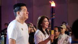 Peraih&nbsp;medali emas olimpiade bulu tangkis, Susi Suasanti (kanan) dan Alan Budikusuma membawa obor saat acara peresmian Aice sebagai es krim ofisial Tim Indonesia di Olimpiade 2024 di Djakarta Theater XXI, Jakarta, Jumat (05/07/2024). (Bola.com/Bagaskara Lazuardi)