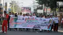 Peserta membawa spanduk mengikuti kegiatan Millenial Road Safety Festival Gorontalo, Minggu (10/2). Kegiatan dilaksanakan sebagai upaya memberikan pengetahuan kalangan millenial di Gorontalo untuk tertib berlalulintas.(Liputan6.com/Rahmad Arfandi Ibrahim)