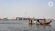 Kapal tradisional melintas dekat proyek pembangunan jembatan penghubung Dadap Tangerang-Pulau C di Kamal Muara, Penjaringan, Jakarta Utara, Minggu (17/11/2019). Jembatan tersebut nantinya akan menghubungkan wilayah Dadap di Tangerang dengan reklamasi Pulau C di Jakarta. (merdeka.com/Iqbal Nugroho)