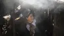 Seorang wanita berdiri di luar oven saat dia bersiap untuk memanggang roti untuk keluarganya di desa Amazigh Timahdite di Atlas Tengah, dekat Azrou, Maroko  (4/12/2021). (AP Photo/Mosa'ab Elshamy)