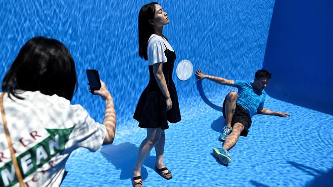 Pengunjung berfoto di karya seni Swimming Pool dalam sebuah pameran pameran bertajuk 