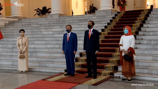PM Suga didampingi istri, Mariko Suga bersama dengan Presiden Jokowi, didampingi Iriana mengikuti prosesi upacara penyambutan.