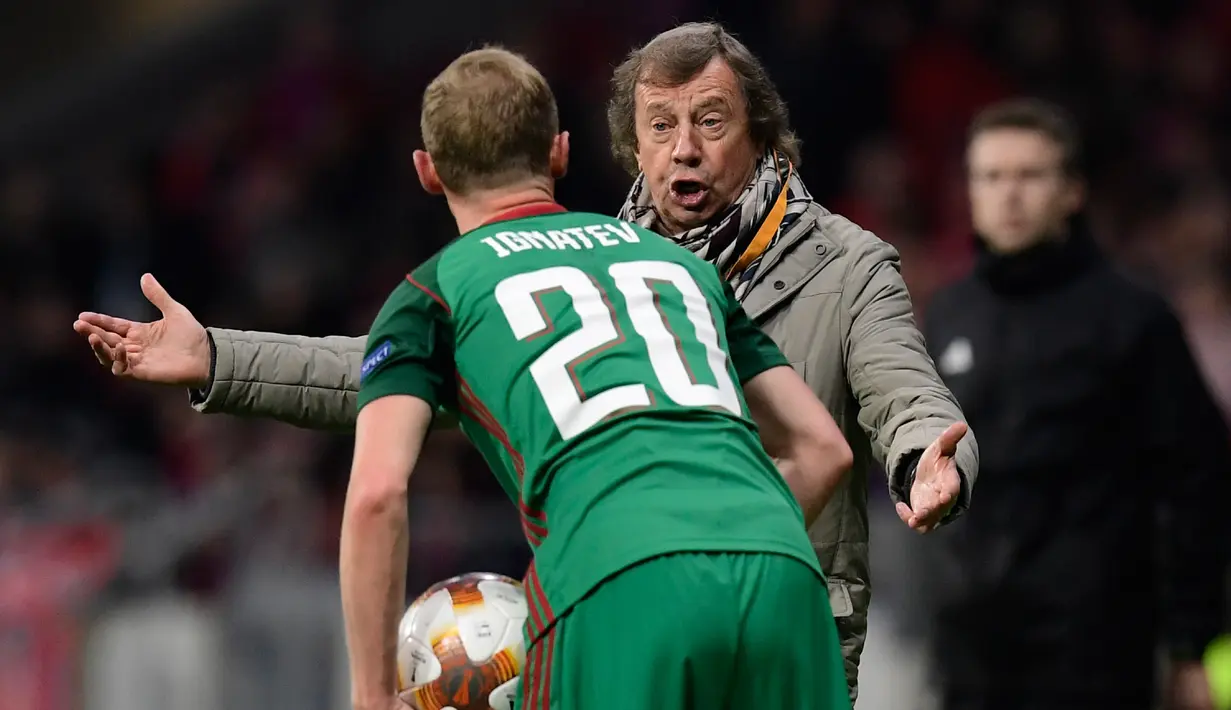 Pelatih Lokomotiv Moskow Yuri Semin memberi arahan kepada pemainnya Vladislav Ignatyev saat bertandang ke markas Atletico Madrid di stadion Wanda Metropolitano, Madrid (8/3). (AFP/Javier Soriano)