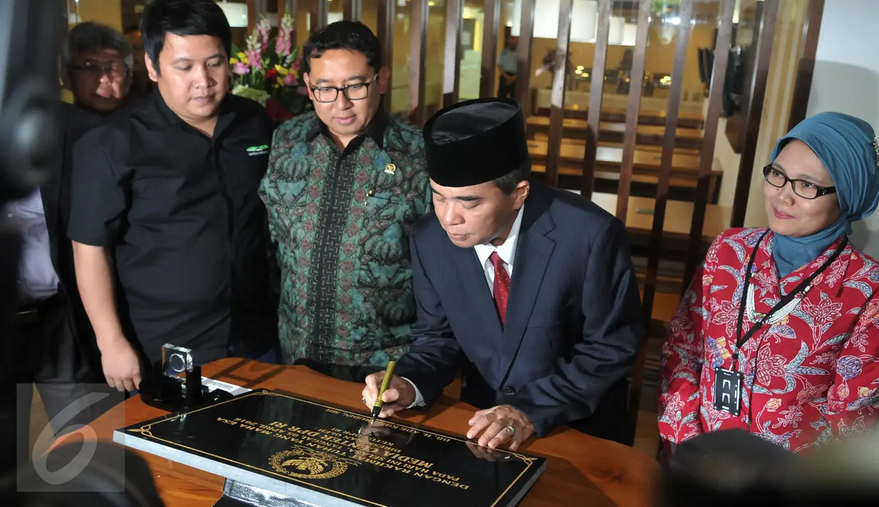 Ketua DPR RI Ade Komarudin (kedua kanan) saat menandatangani prasasti peresmian ruangan wartawan parlemen di Gedung Nusantara III, Jakarta, Selasa (5/4). Ruangan itu diperuntukan bagi para pewarta berita yang ada di DPR. (Liputan6.com/Johan Tallo)