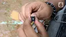 Seorang anak yang tergabung dalam Ketapel Anak Ciliwung (Kancil) saat bermain ketapel di kawasan Ciliwung Muara Baru, Jakarta, Selasa (9/11/2021). Selain melestarikan permainan tradisional, bermain ketapel melatih kesabaran, konsentrasi dan motorik otak kanan anak. (Liputan6.com/Herman Zakharia)