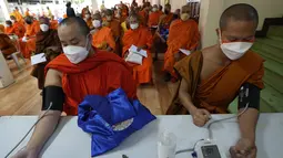 Biksu Buddha memeriksa tekanan darah mereka sebelum menerima vaksin AstraZeneca COVID-19 di Wat Srisudaram di Bangkok, Thailand (30/7/2021).  Thailand pada hari Kamis mencatat rekor satu hari baru dengan 17.669 kasus dan 165 kematian. (AP Photo/Sakchai Lalit)