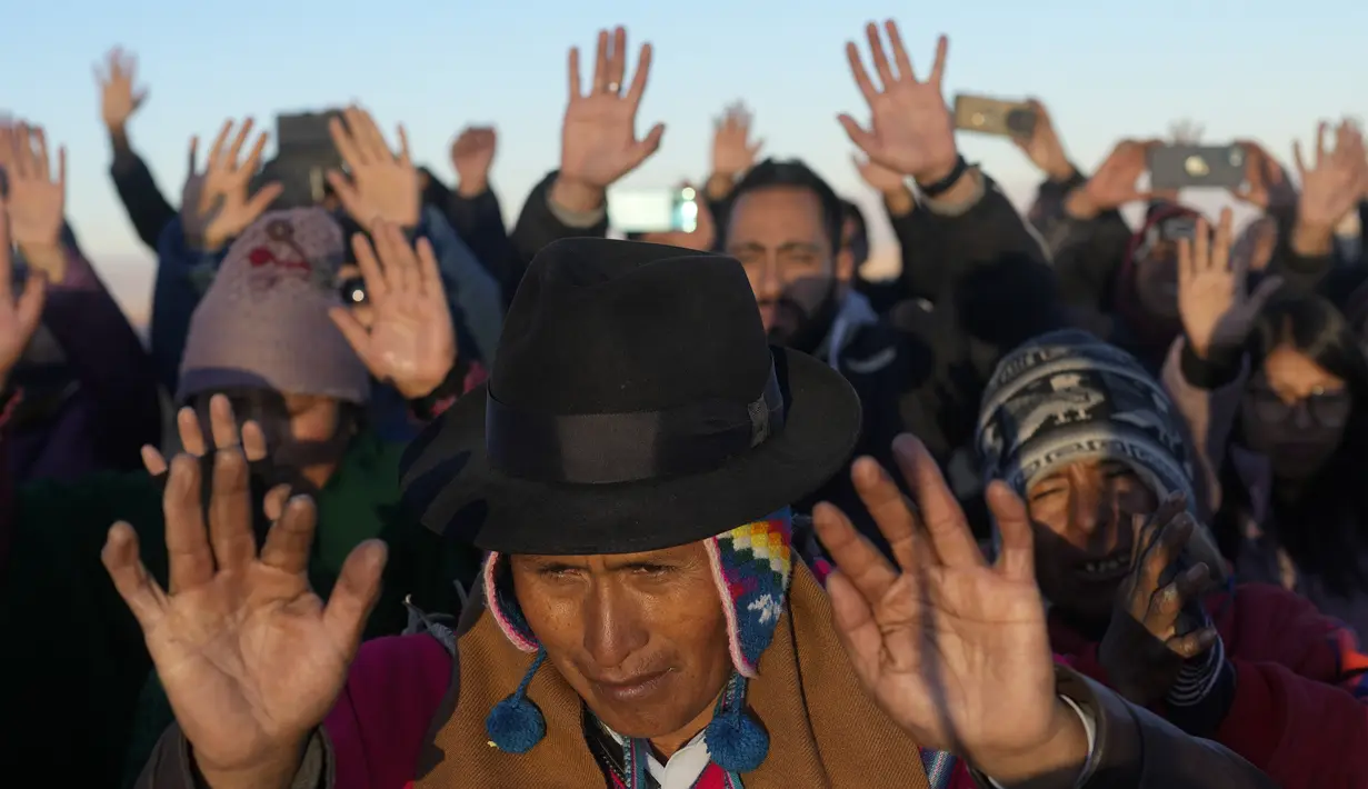 Masyarakat Adat Aymara menerima sinar matahari pertama dalam ritual Tahun Baru di gunung suci Apacheta Murmutani di pinggiran Hampaturi, Bolivia, Rabu dini hari, 21 Juni 2023. (AP Photo/Juan Karita)