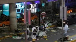 Petugas forensik memeriksa jasad korban ledakan bom di Bandara Atarturk, Istanbul, Turki, Selasa (28/6). Pejabat otoritas setempat, menyebut para pelaku meledakkan diri setelah polisi menembaki mereka di pintu masuk terminal bandara. (REUTERS/Murad Sezer)