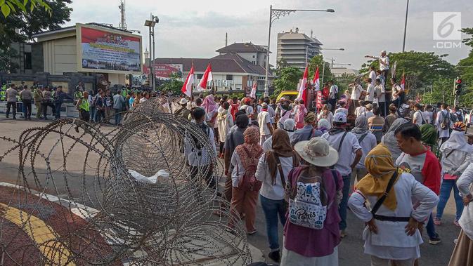 Petugas berjaga saat unjuk rasa ratusan massa di Perempatan Jalan Pahlawan Semarang,  Jumat (10/5). Mereka menuntut kejujuran penghitungan suara KPU pada Pemilu 2019. (Liputan6.com/Gholib)