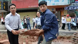 Sejumlah petugas mengangkat fosil telur Dinosaurus , Heyuan, Tiongkok, Kamis (23/4/2015). Telur dibawa untuk diteliti oleh para ahli dari Heyuan Dinosaur Museum (AFP Photo/China Out)