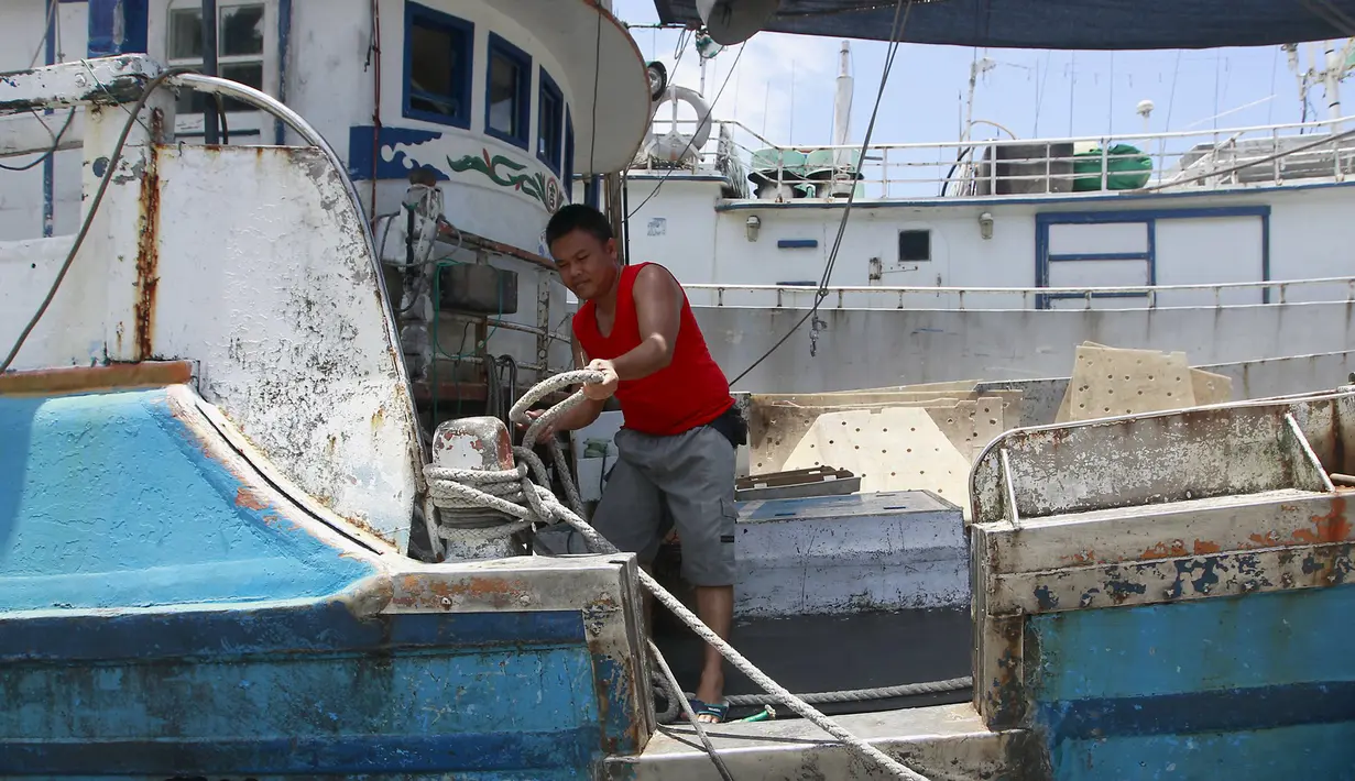 Seorang nelayan mengikat perahu di pelabuhan akibat badai Topan Chan-hom yang mendekati wilayah pesisir timur laut Nanfangao di Ilan County, Taiwan Utara, (9/7/2015). Akibat Topan Chan-hom para nelayan berhenti melaut sementara. (REUTERS/Pichi Chuang