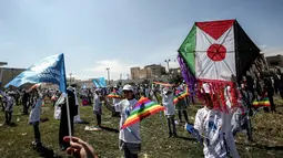 Anak-anak sekolah Palestina menerbangkan layangan berbendera Palestina dan Jepang dalam aksi solidaritas peringatan tujuh tahun gempa dan tsunami Jepang di Gaza, Selasa (13/3). (SAID KHATIB/AFP)