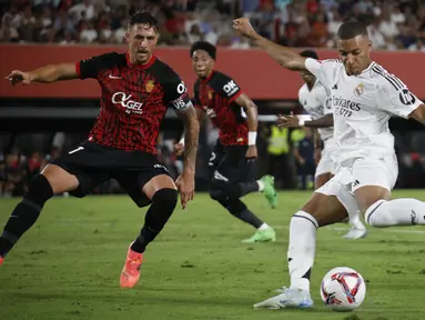 Pemain Real Madrid, Kylian Mbappe (kanan) berusaha mencetak gol ke gawang Real Mallorca pada laga Liga Spanyol 2024/2025 di Mallorca Son Moix stadium, Spanyol, Senin (19/08/2024) dini hari WIB. (AP Photo/Francisco Ubilla)