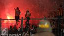Suporter menyalakan flare saat menyaksikan laga Persija melawan Sriwijaya FC pada lanjutan Torabika Soccer Championship presented by IM3 Ooredoo di Stadion GBK Jakarta, Jumat (24/6).Laga dihentikan di menit 81. (Liputan6.com/Helmi Fithriansyah)