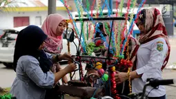 Warga sedang menghias Betor (becak motor) di depan kantor Dinas Perhubungan, Medan, Sumatera Utara, Sabtu (25/11). Puluhan betor akan ramaikan kirab budaya di komplek Bukit Hijau Regency. (Liputan6.com/Endang Mulyana)