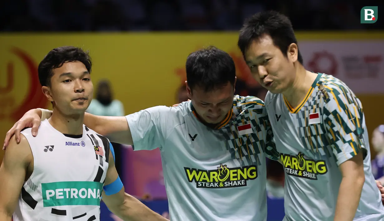 Ganda putra Indonesia, Hendra Setiawan, berusaha menangkan Mohammad Ahsan yang bersedih setelah tersingkir dari Indonesia Masters 2025 di Istora Senayan Jakarta, Kamis (23/1/2025). (Bola.com/Abdul Aziz)