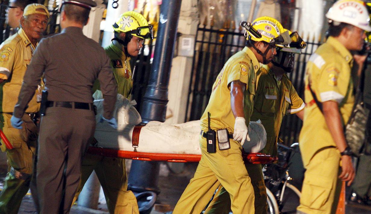 Petugas membawa tubuh korban ledakan bom motor di luar Kuil Erawan di pusat kota Bangkok, Thailand, Senin (17/8/2015). Bom motor tersebut diketahui telah menewaskan sekitar 27 warga. (REUTERS/Athit Perawongmetha)