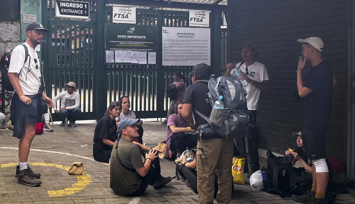 Turis menunggu di luar stasiun kereta Machu Picchu setelah layanan kereta api dihentikan karena kerusakan yang diduga disebabkan oleh pengunjuk rasa di Machu Picchu, Peru, Sabtu (21/1/2023). Layanan kereta api ke Machu Picchu dihentikan pada Kamis (19/01/2023) dan beberapa jalur kereta telah rusak, diduga oleh pengunjuk rasa. (Photo by Carolina Paucar / AFP)