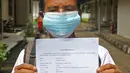 Pasien sembuh COVID-19 memperlihatkan surat keterangan selesai isolasi di Graha Wisata Ragunan di Jakarta, Jumat (29/1/2021). Data Satgas Covid-19 per Jumat (29/1), jumlah pasien yang sembuh bertambah 10.138 orang dengan total pasien sembuh mencapai 852.260 orang. (Liputan6.com/Herman Zakharia)
