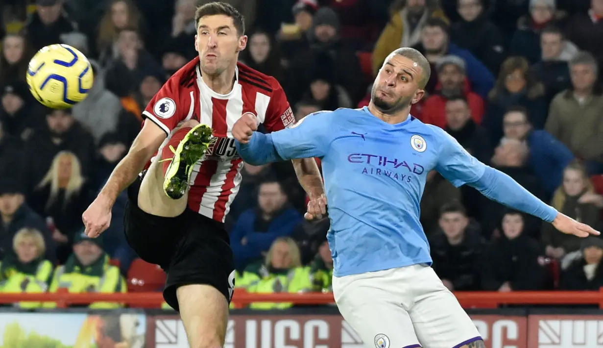 Pemain Sheffield United, Chris Basham berebut bola dengan bek Manchester City, Kyle Walker pada pekan ke-24 Liga Inggris di Bramall Lane, Selasa (21/1/2020). Man City berhasil membawa pulang kemenangan saat berkunjung ke markas Sheffield United dengan skor tipis 1-0. (AP/Rui Vieira)
